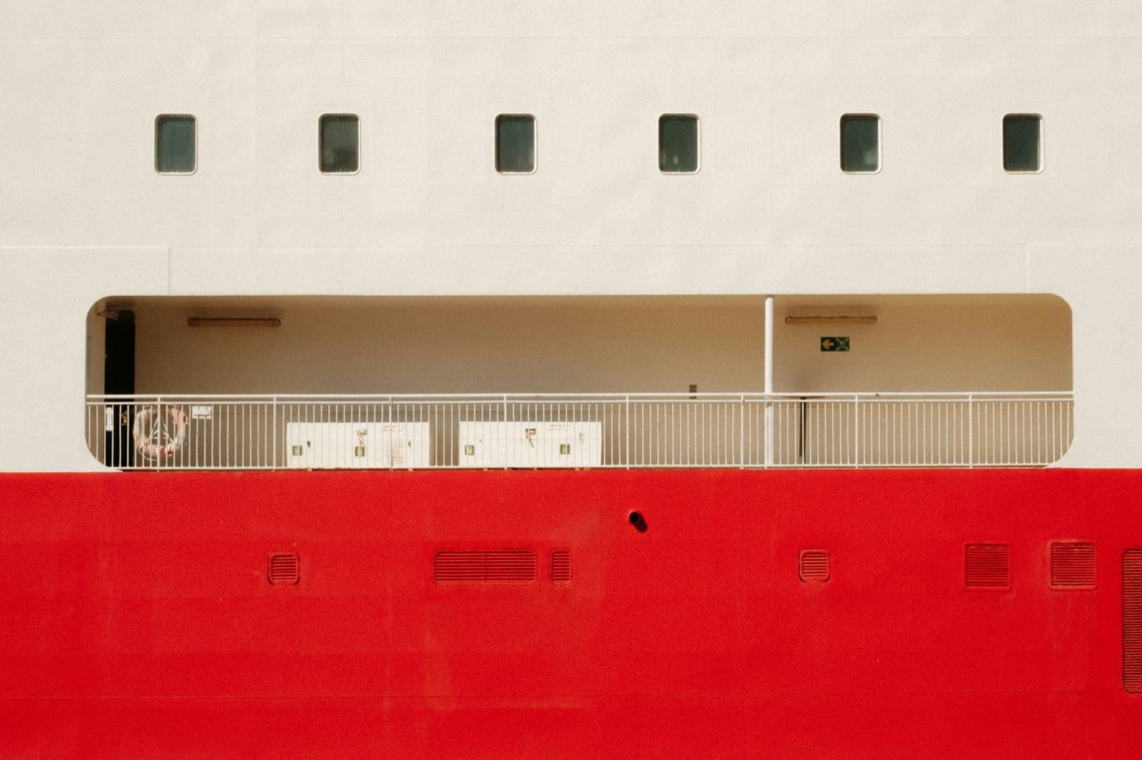 White ship hull with a red lower band and a row of small windows